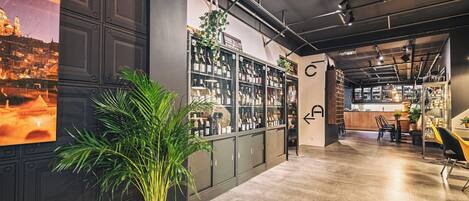 A modern bar with a large wine rack, a potted plant, and a view of a cityscape.