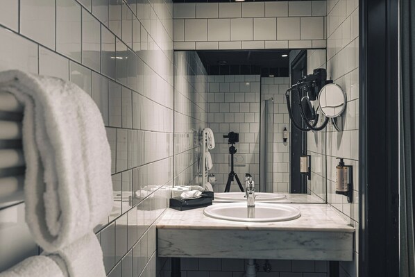 Une salle de bain moderne avec un lavabo en marbre, un porte-serviettes et un miroir.