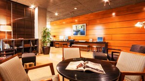 A lobby with a wooden reception desk, seating area, and a large plant. - Hotel Granollers (Granollers)