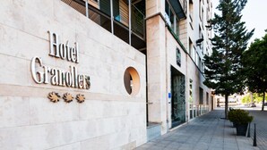 A building with a sign reading "Hotel Granollers" and a tiled sidewalk. - Hotel Granollers (Granollers)