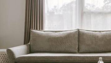 Suite Deluxe | Area soggiorno | TV a schermo piatto 42 pollici con canali digitali, TV