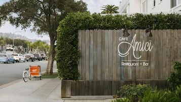 A wooden fence with a sign for 'Cafe Amici Restaurant + Bar'.