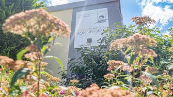 A sign for Parkhotel Sonnenberg with a view of surrounding greenery.