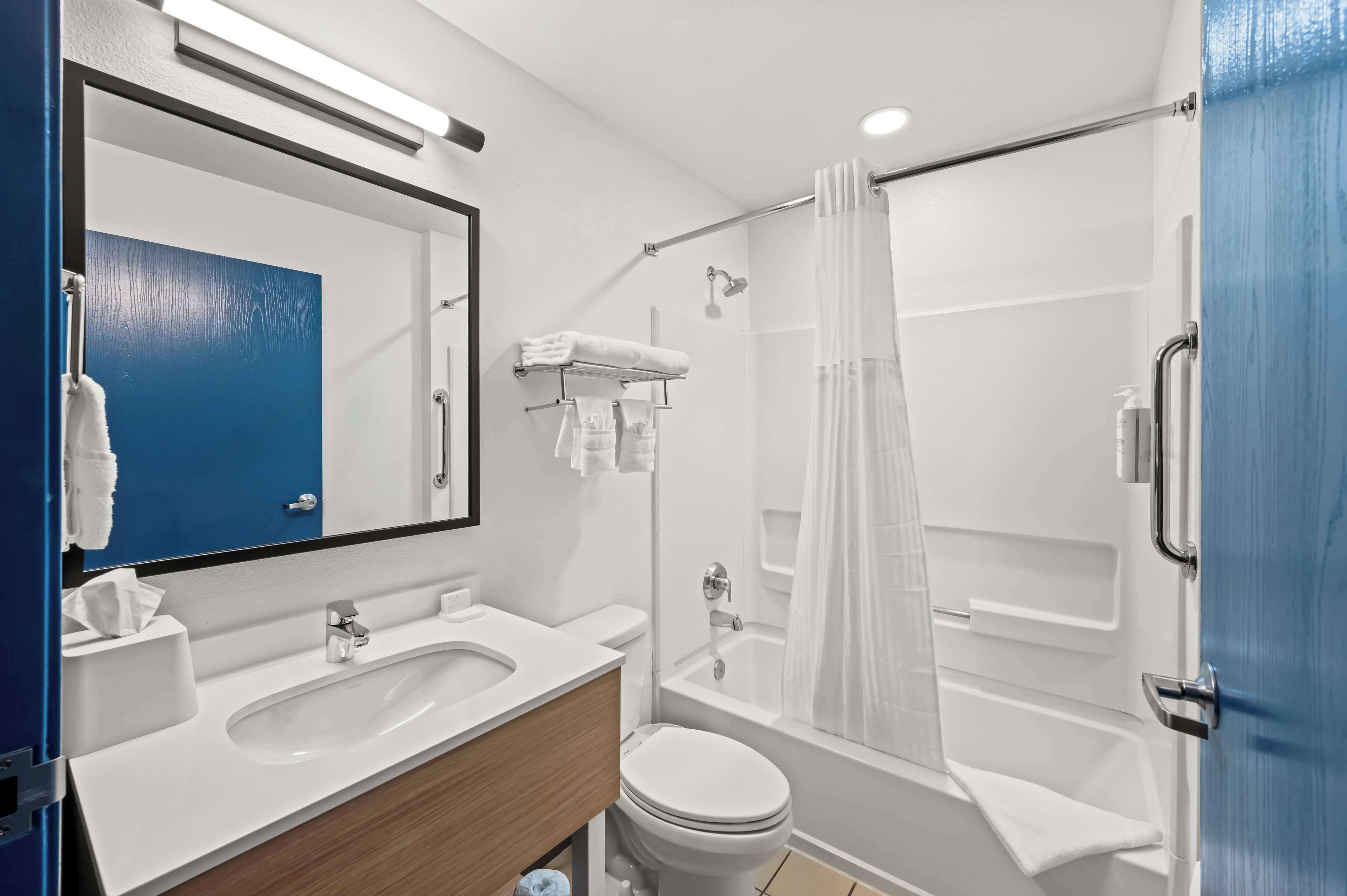 Un baño moderno con lavamanos, inodoro y ducha.