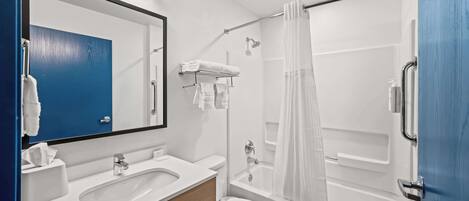 Un baño moderno con lavamanos, inodoro y ducha.