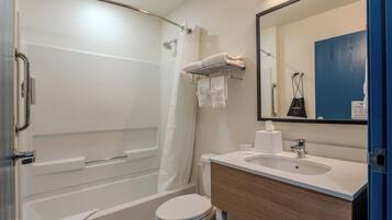 Een moderne badkamer met een bad, toilet en wastafel.