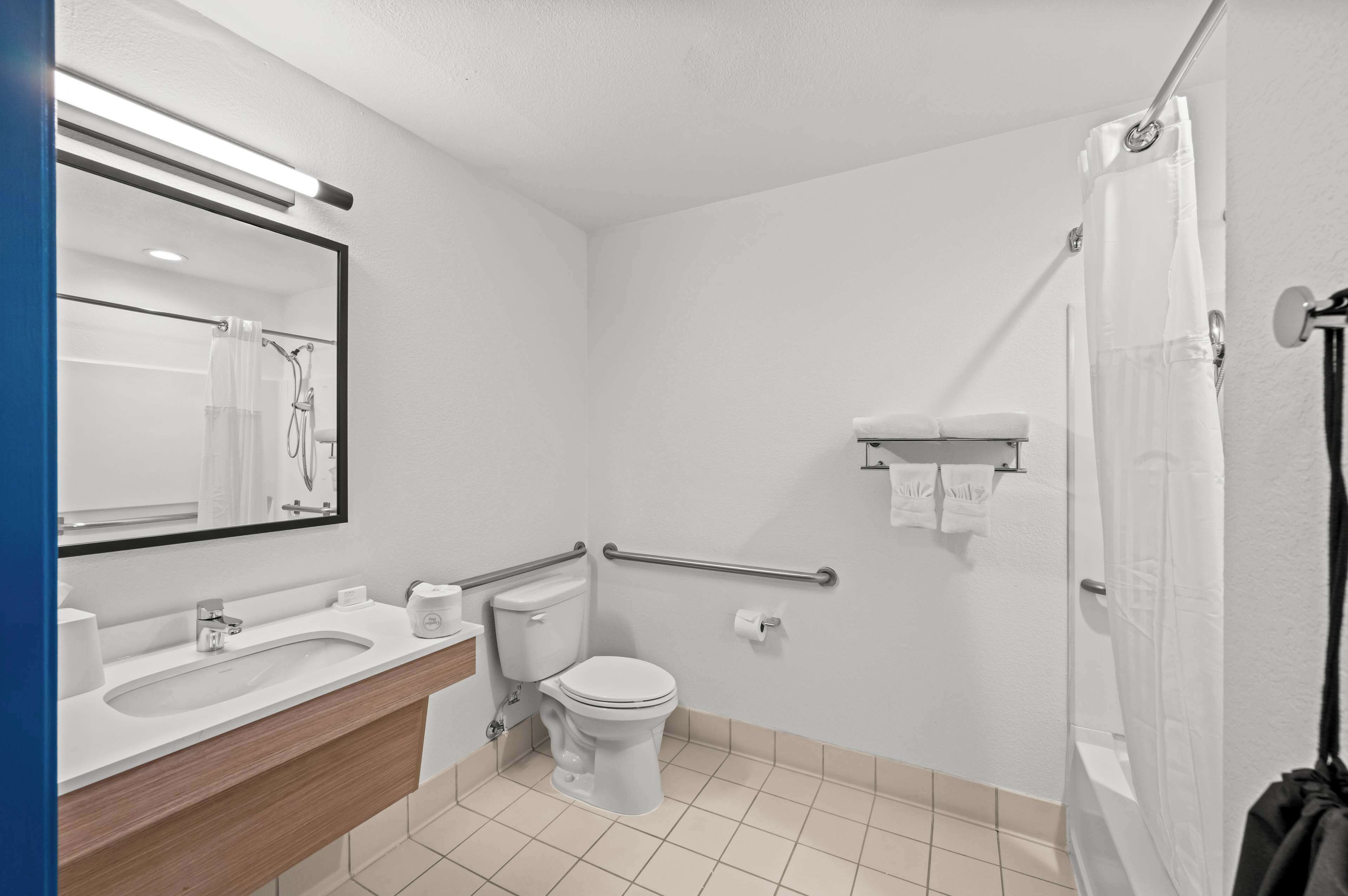 Un bagno moderno con lavandino, water e doccia.