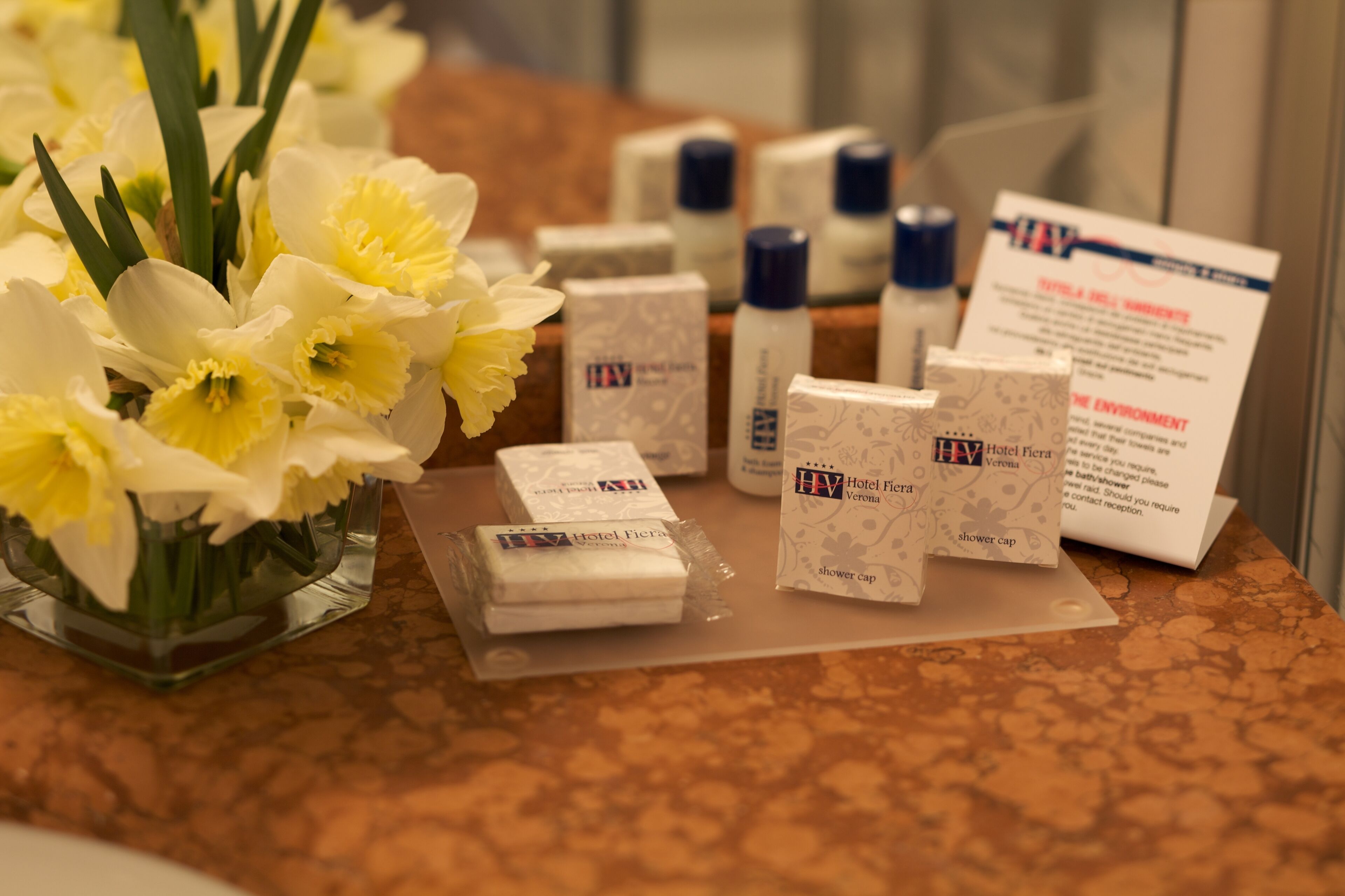 A hotel reception area with a display of toiletries and a sign about the hotel's environmental policy.