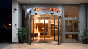 The entrance of Hotel Fierna with a glass door, potted plants, and a reception area visible inside. - Best Western Hotel Fiera Verona (Verona)