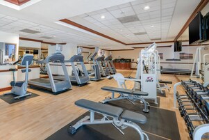 A gym with treadmills, elliptical machines, and weight benches.