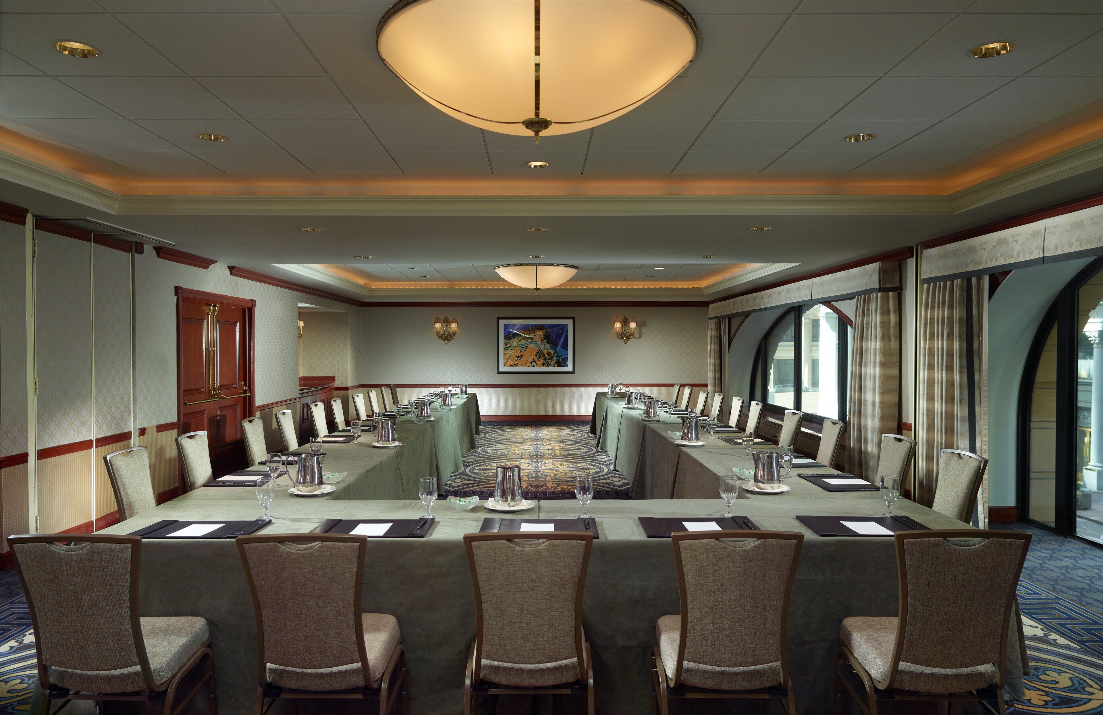 A conference room with a long table, chairs, and a chandelier.