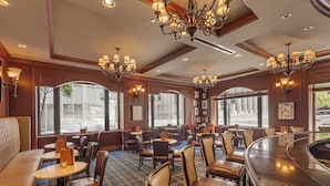 A restaurant with a bar area, multiple seating options including booths and tables, and large windows providing views of the street. - Omni San Francisco Hotel (San Francisco)