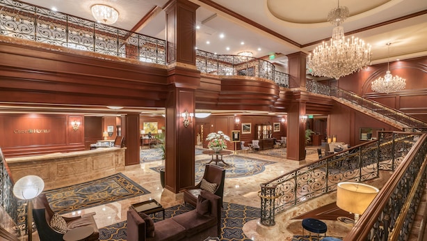 A grand lobby with a marble floor, a staircase, and a chandelier. - Omni San Francisco Hotel (San Francisco)