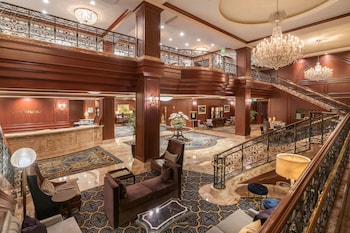 A restaurant with a bar area, multiple seating options including booths and tables, and large windows providing views of the street. at Omni San Francisco Hotel