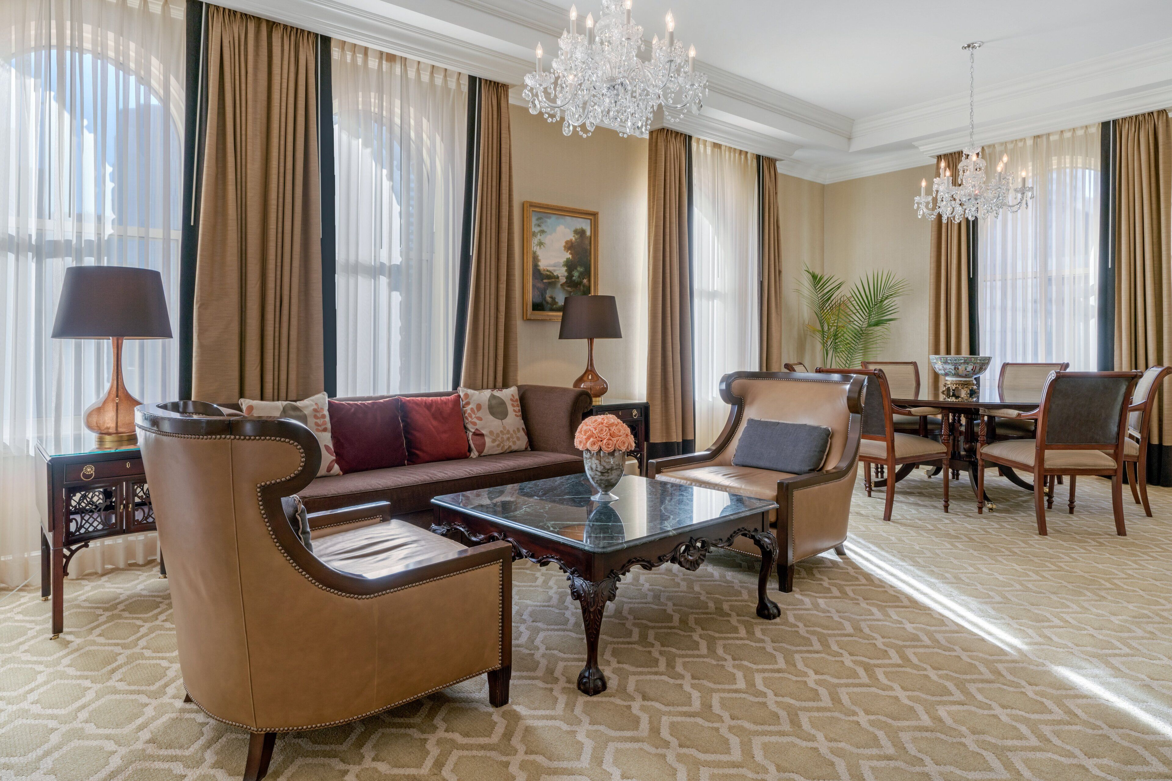 Un salon spacieux comprenant un canapé, des fauteuils, une table basse et un coin repas avec une table et des chaises.