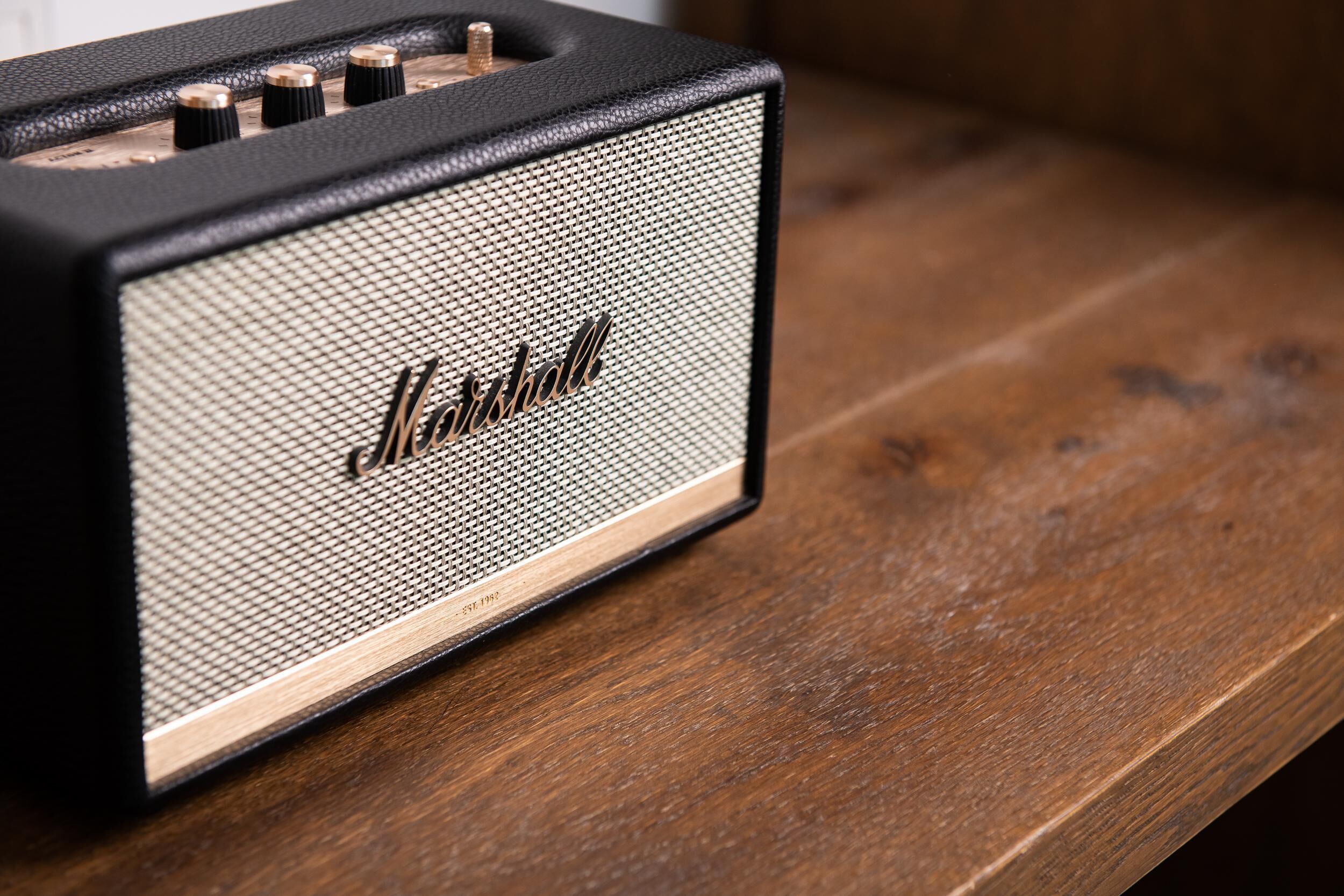 A Marshall amplifier on a wooden surface.