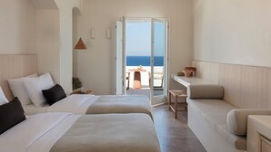 A hotel room with two beds, a balcony, and a view of the sea.