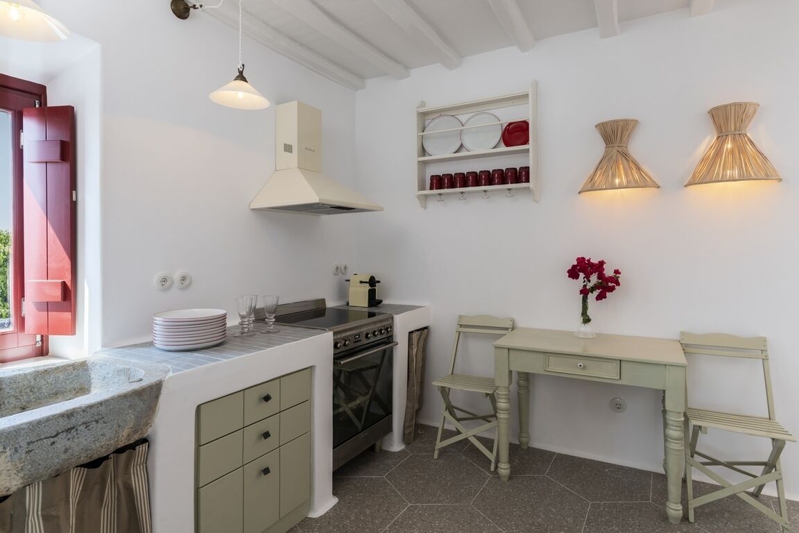 A compact kitchen with a stove, oven, and hanging light fixtures.