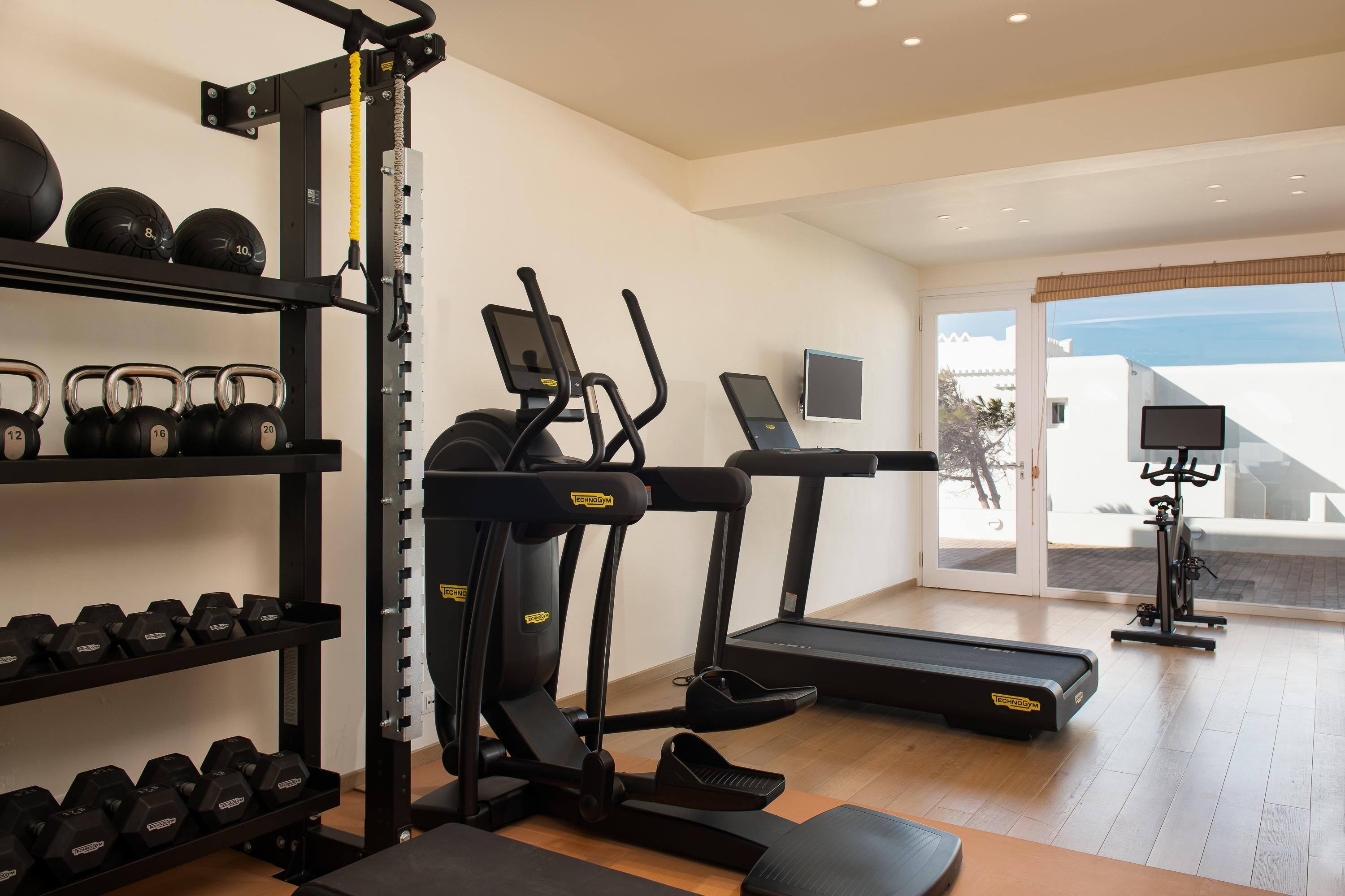 A gym with treadmills, a stationary bike, and weightlifting equipment.