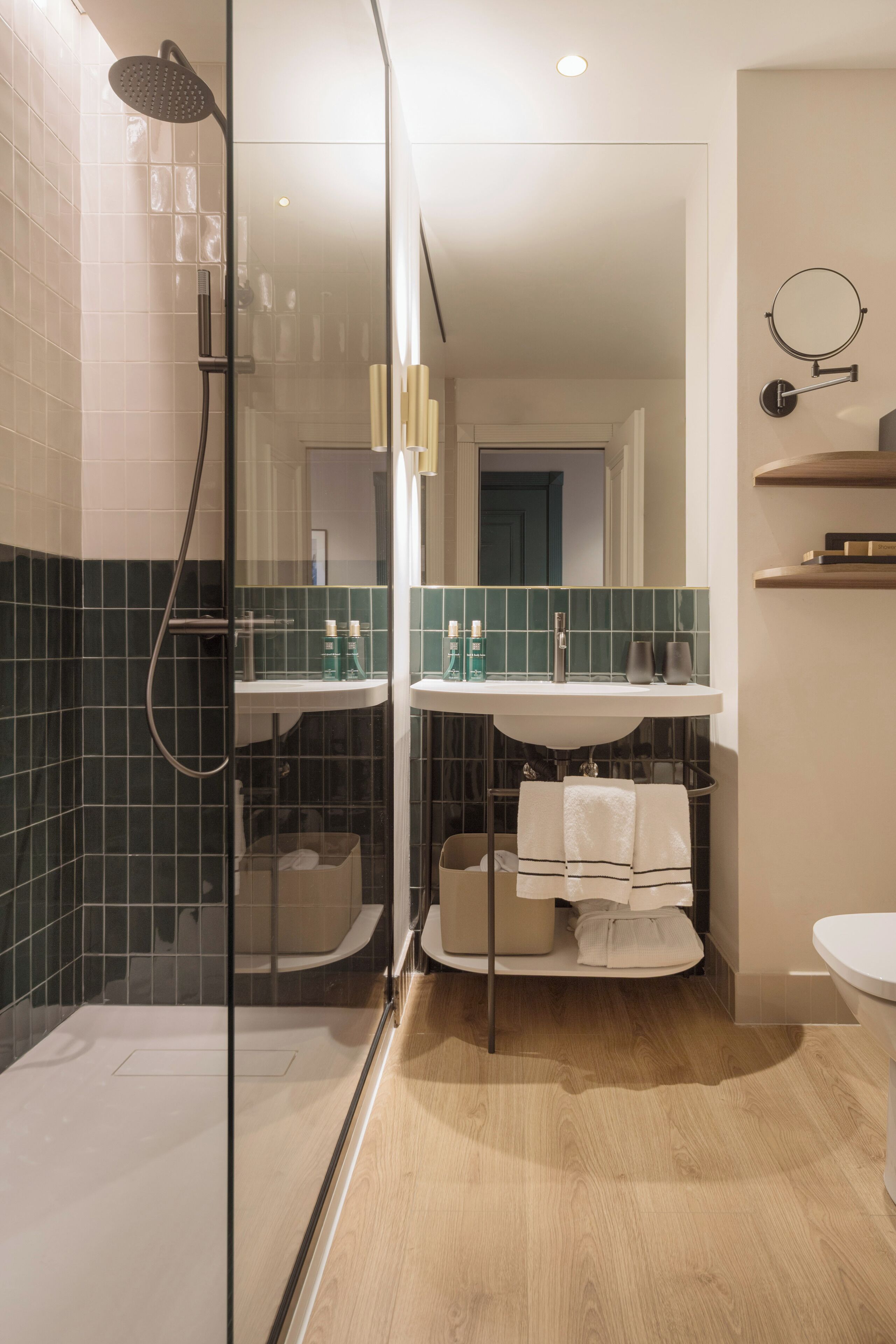 A modern bathroom with a glass-enclosed shower, a sink with a mirror, and a toilet.