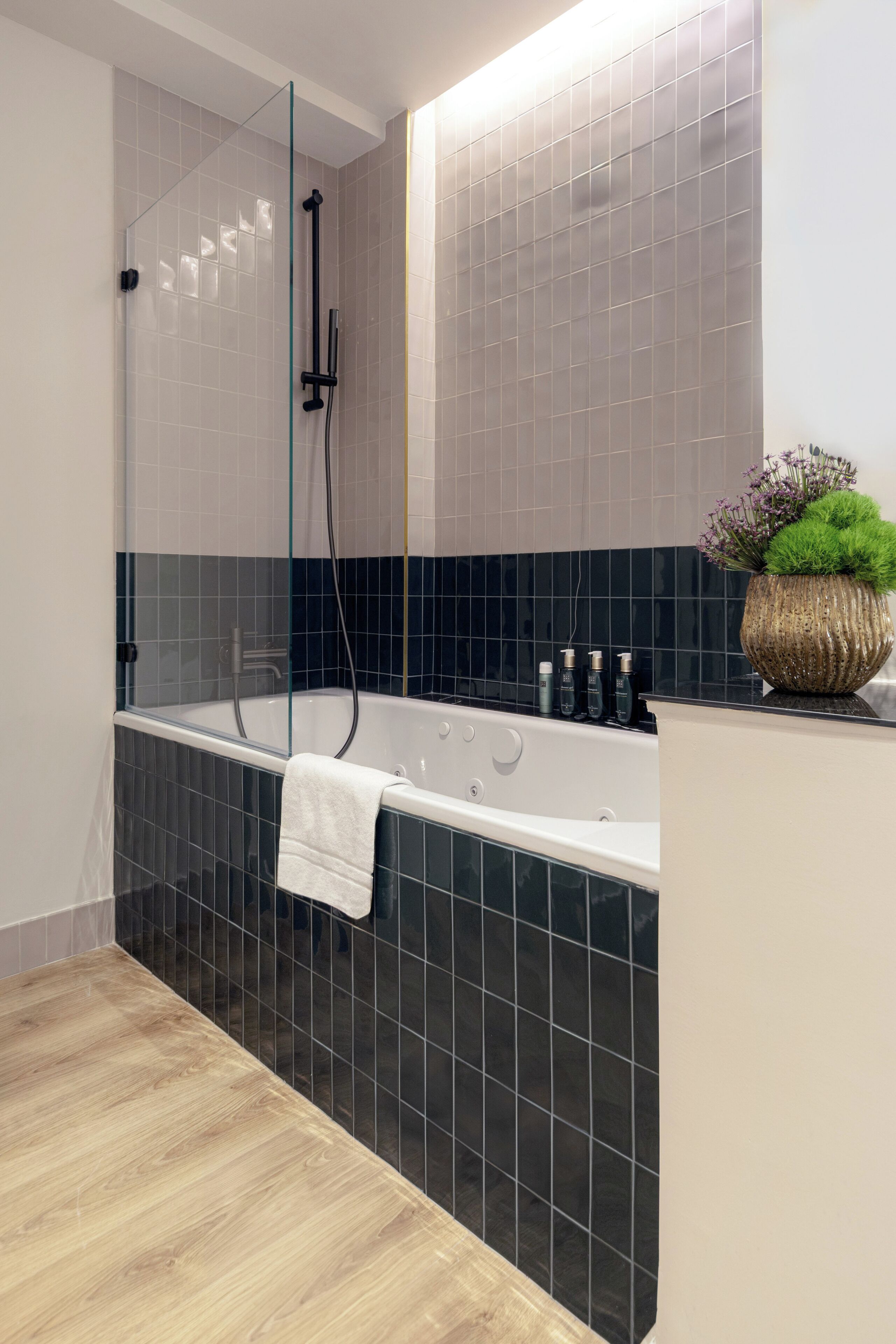 A modern bathroom with a glass-enclosed shower, a freestanding bathtub, and a large mirror.
