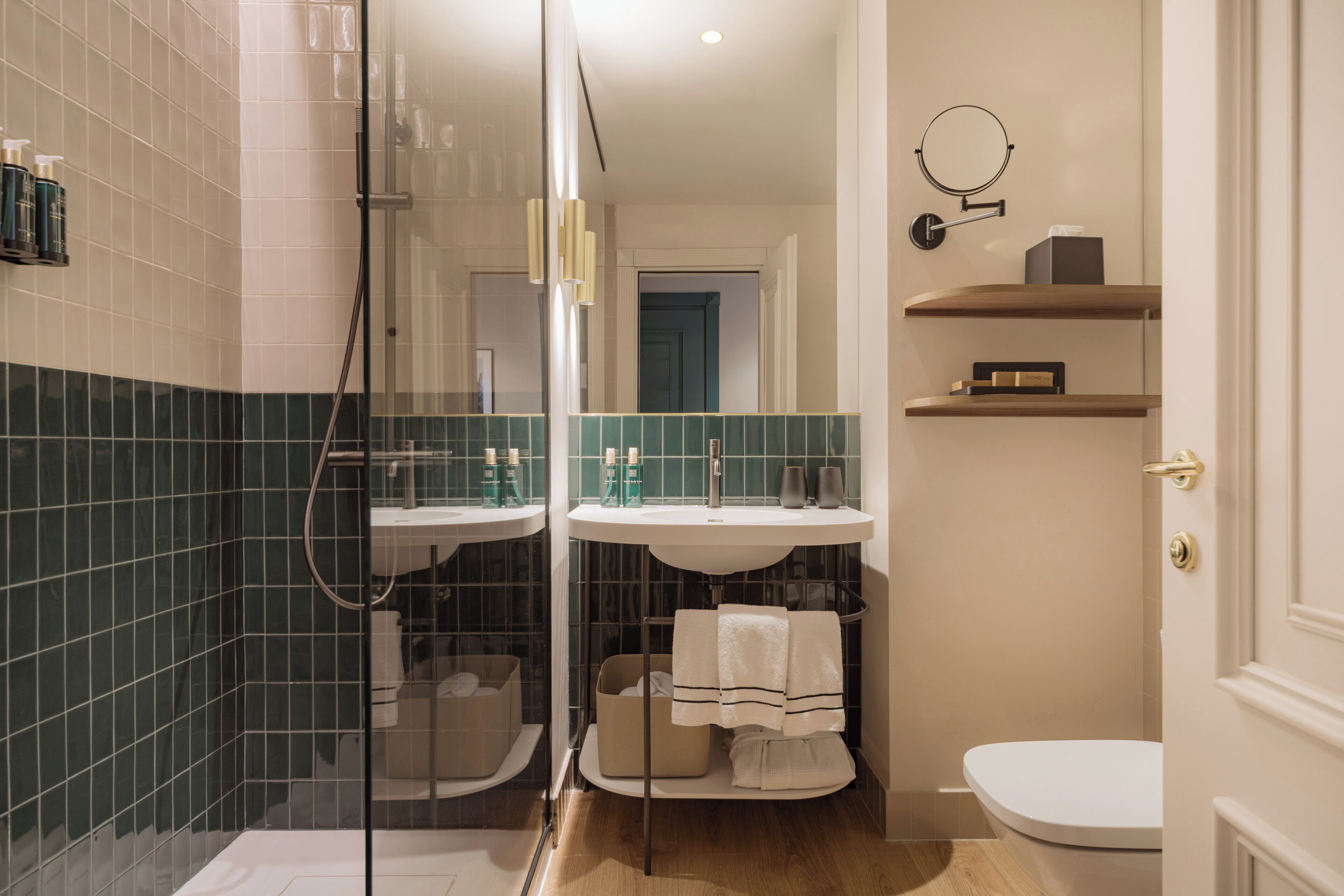 Un bagno moderno con box doccia in vetro, due lavabi e un water.