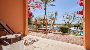 Relax in a serene outdoor space with a pool view, lounge chairs, and a shaded pergola.