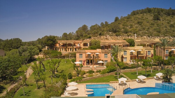 Una piscina techada, una piscina al aire libre, sombrillas