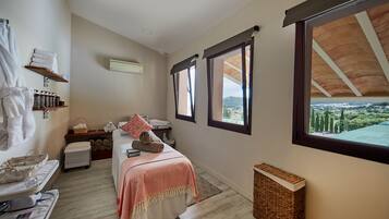 Enjoy a scenic view from the window in this cozy room featuring a large bed and a sitting area.