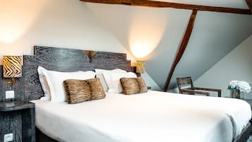 Un dormitorio con una cama grande, cabecera de madera oscura y dos lámparas de pared con pantallas a rayas de cebra.