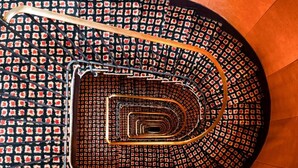A spiral staircase with a patterned floor and metal railings.