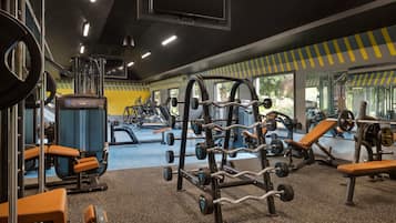 A gym with various exercise equipment, including weight machines and benches.
