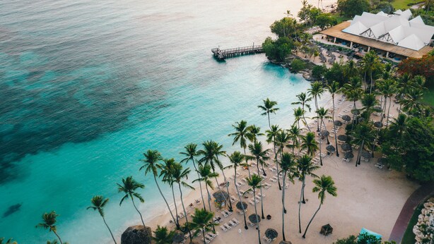 A coastal resort with a beach, palm trees, and a pier. - Dreams La Romana Resort & Spa - All Inclusive (San Rafael del Yuma)
