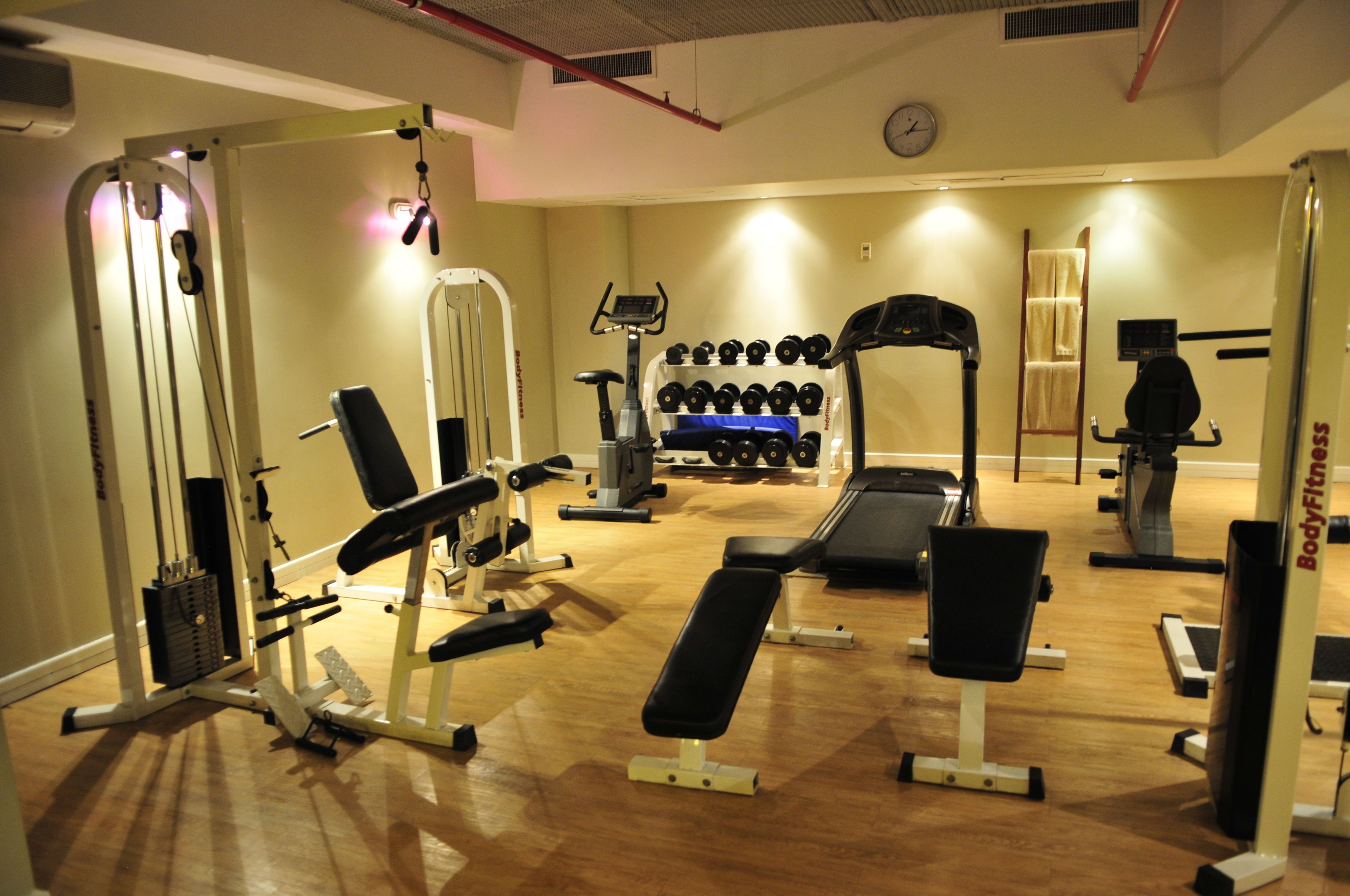 A gym with various exercise equipment, including dumbbells, treadmills, and weight machines.