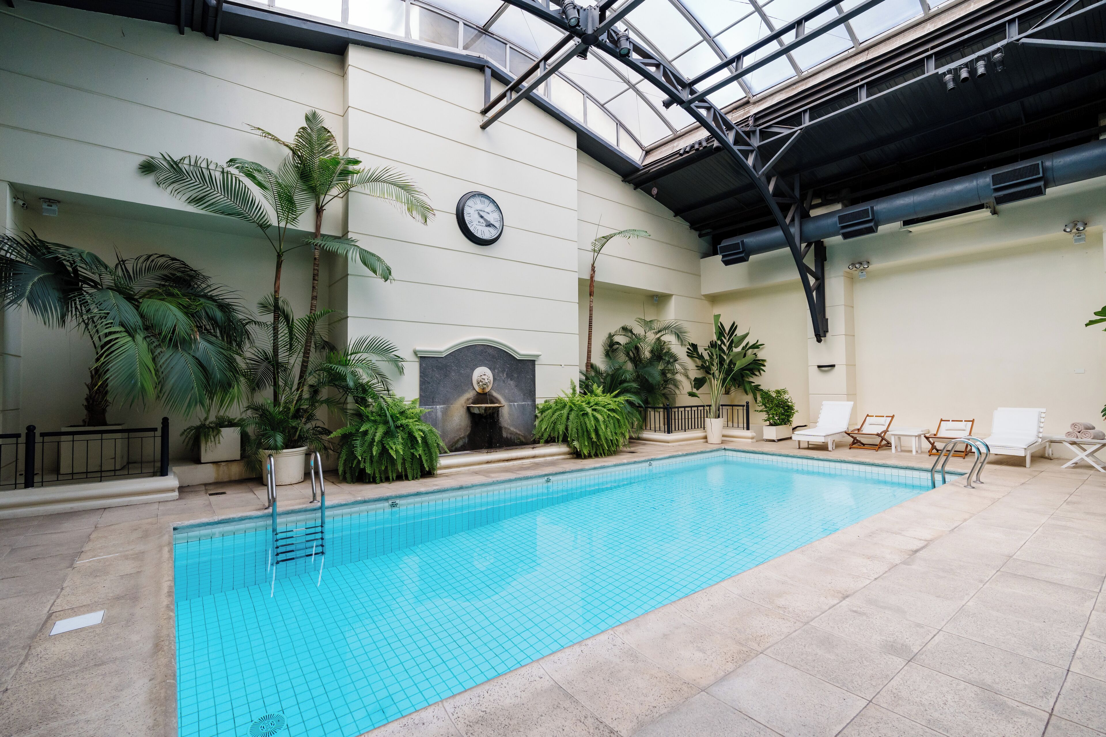 Una piscina techada, sillones reclinables de piscina