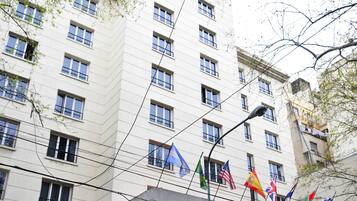 A multi-story hotel with a central entrance featuring a portico supported by columns.