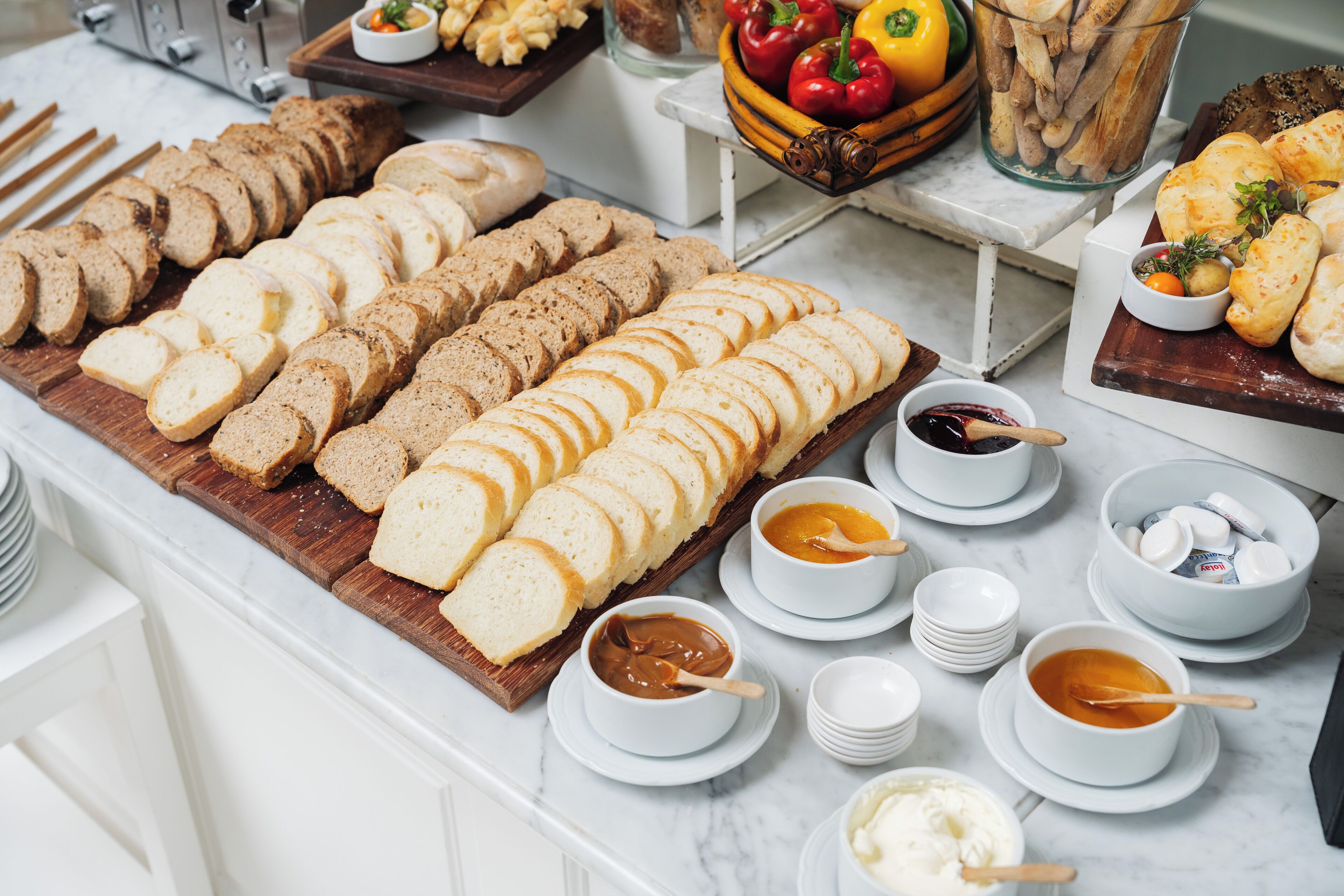 A buffet table with various sliced breads and spreads.