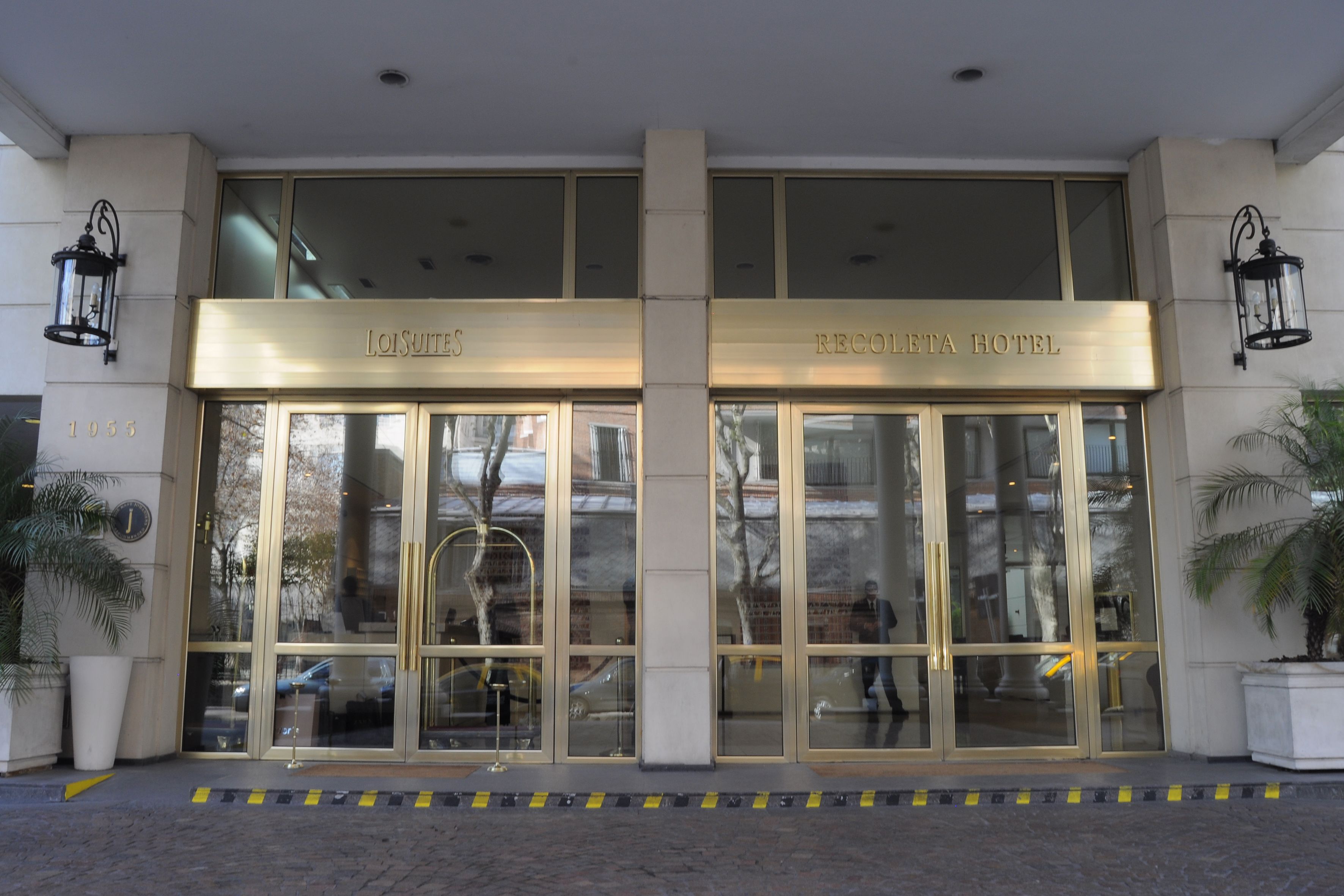 The entrance to the Lo Suites and Recologia Hotel, featuring large glass doors and a modern facade.