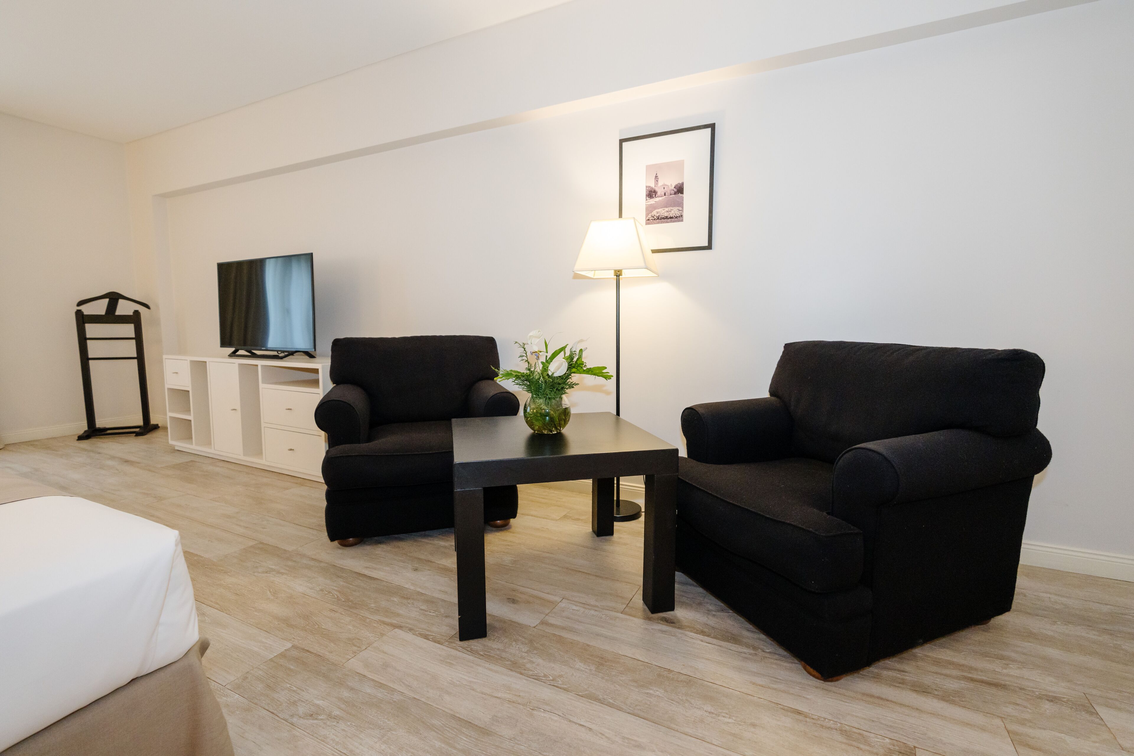 A modern living room with a sofa, a coffee table, a TV, and a lamp.