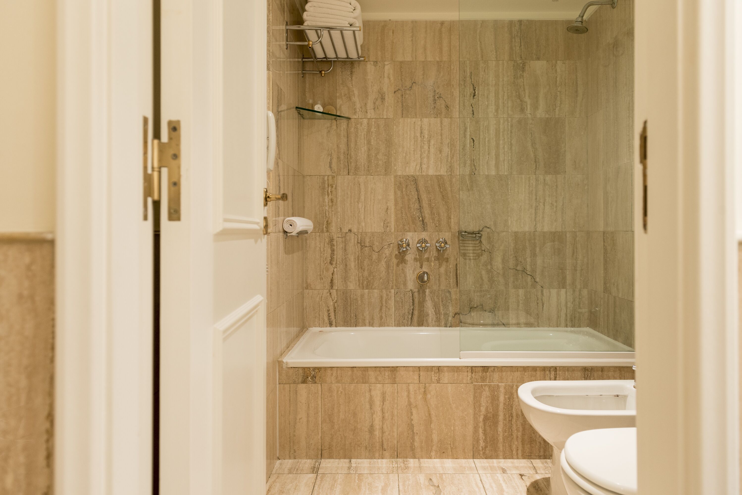 Un baño con bañera, inodoro y zona de ducha.