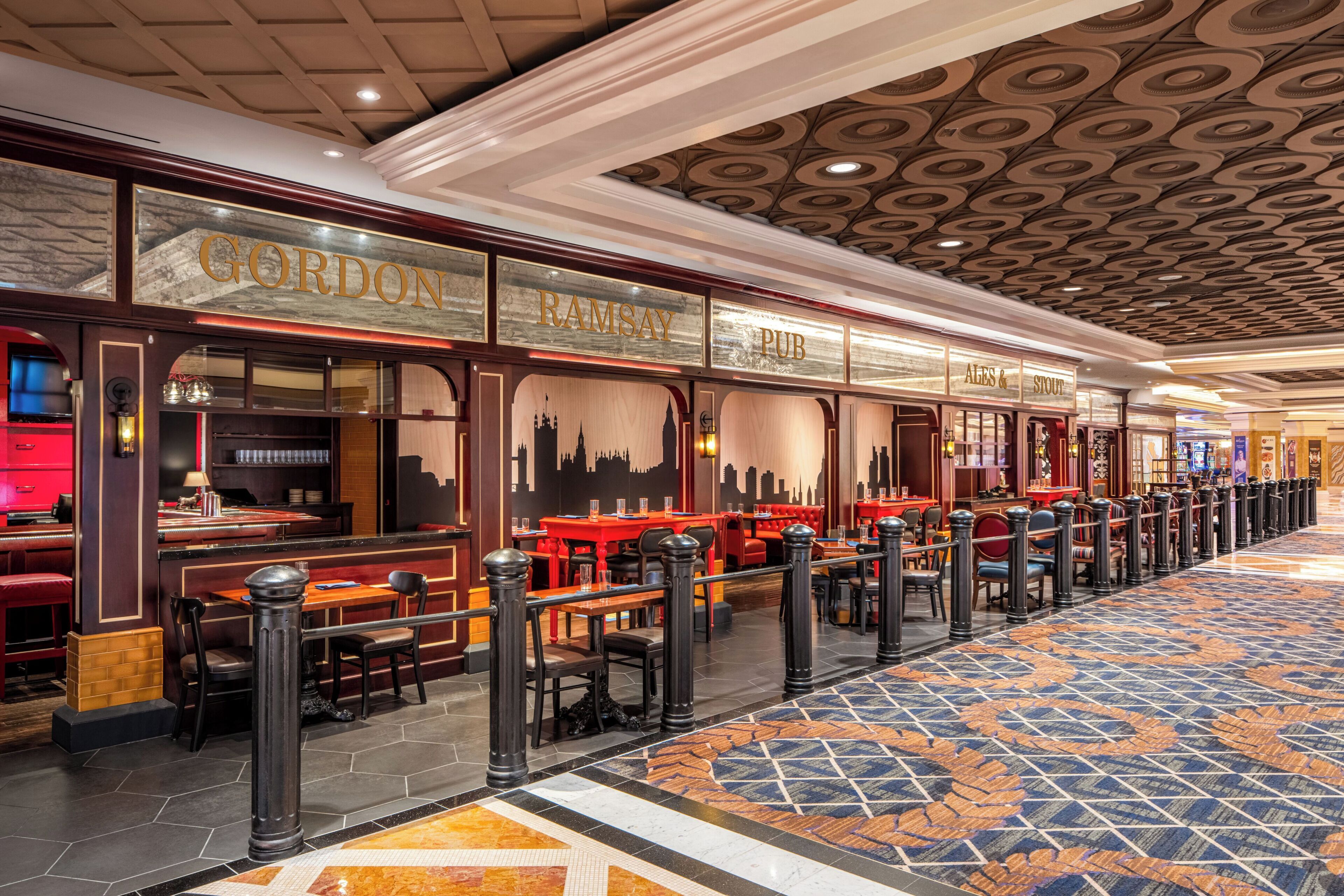 A long corridor with multiple seating areas, a patterned floor, and a ceiling with circular designs.