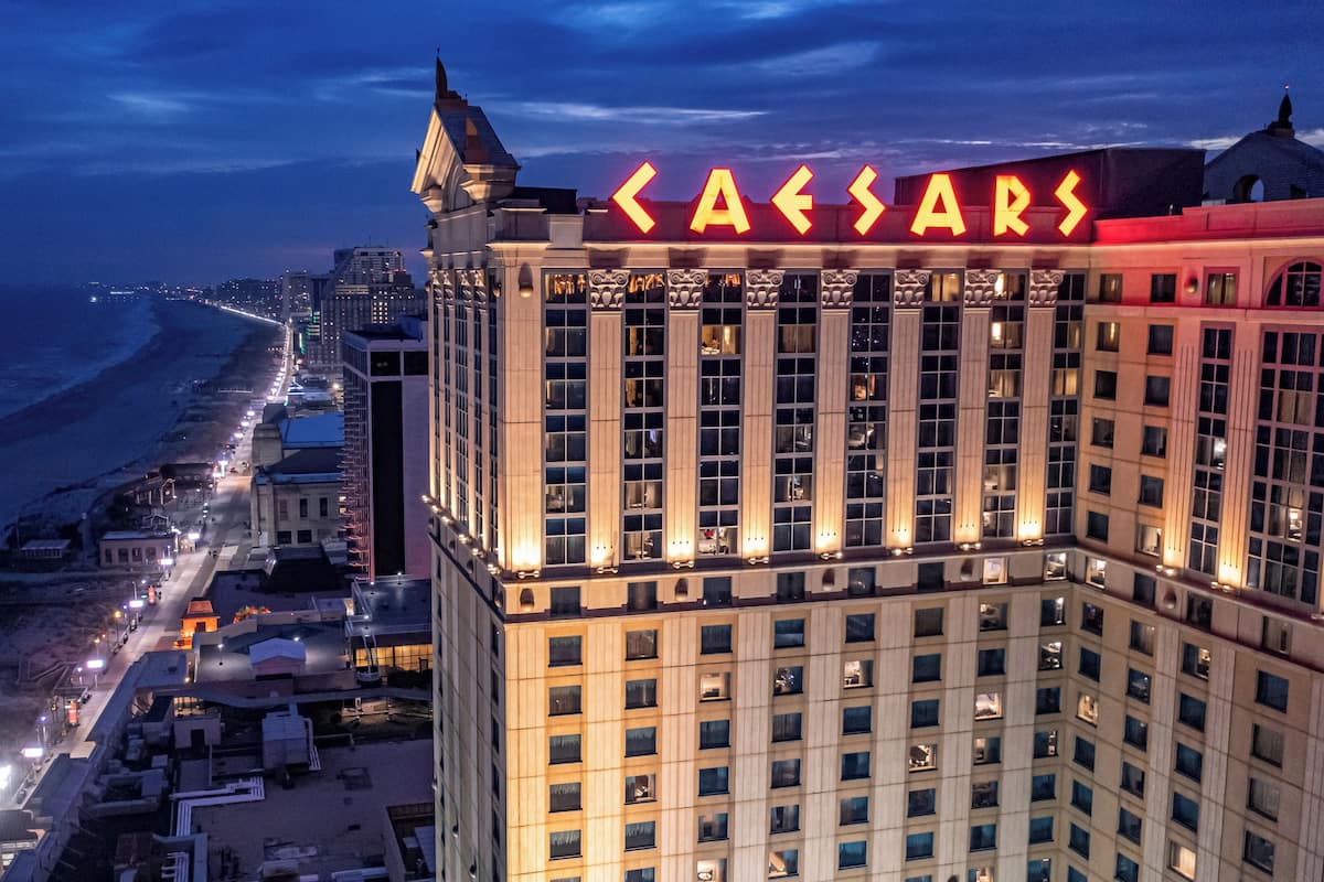 Ein Hochhaus-Hotel mit einem markanten 'Caesars'-Schild, das einen klassischen Baustil mit zahlreichen Fenstern und einem Eckturm aufweist.