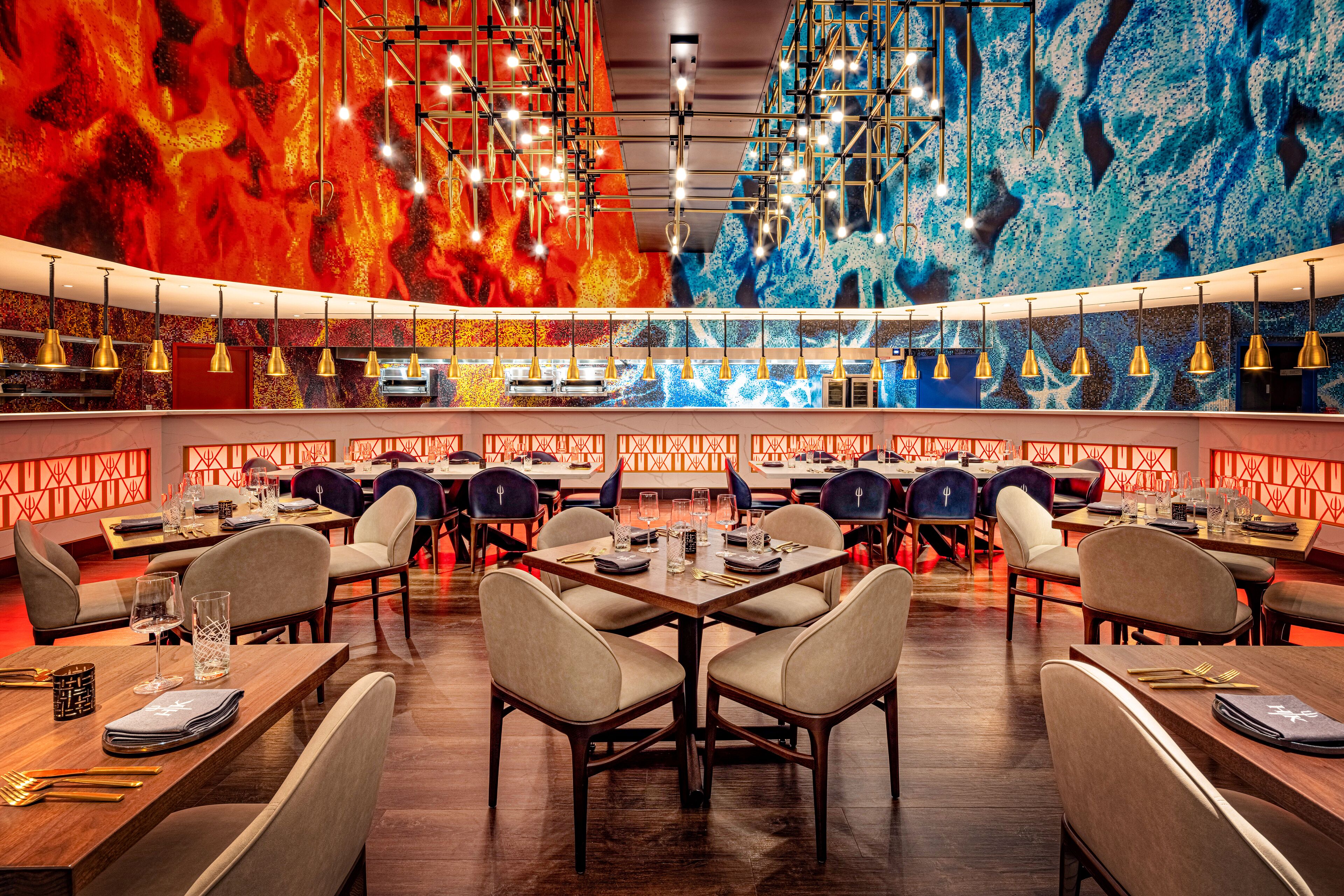 A modern restaurant with round tables, high ceilings, and vibrant wall murals.