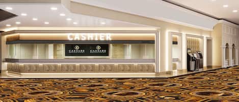 A hotel lobby with a cashier counter, patterned carpet, and columns.