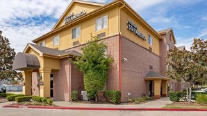 A two-story hotel with 'Extended Stay America' branding, featuring a brick facade, a covered entrance, and a well-maintained exterior. - Extended Stay America Select Suites - Houston - Sugar Land (Sugar Land)