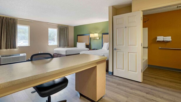 A hotel room with a desk, two beds, a bathroom, and a view of the outdoors. - Extended Stay America Select Suites - Houston - Sugar Land (Sugar Land)