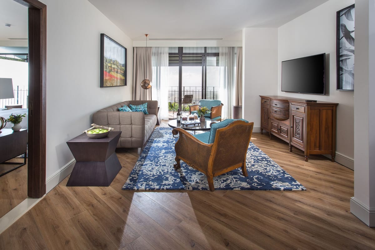 A living room with a sofa, coffee table, and a television.