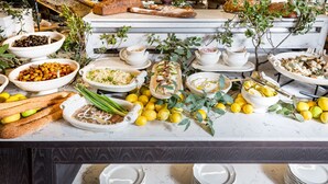 Un tavolo del buffet con diversi piatti, limoni e una piccola pianta.