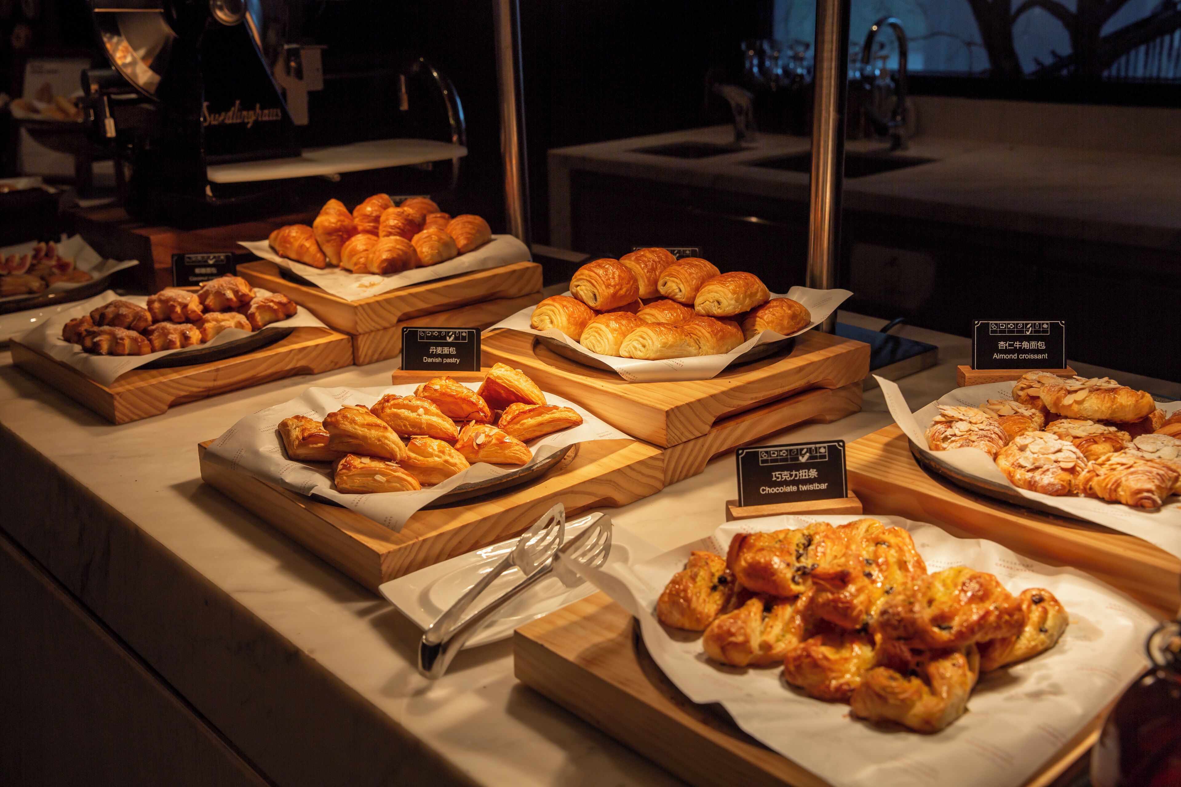 A bakery display with various pastries and a coffee machine.