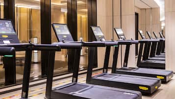 A row of stationary bikes with control panels, likely in a hotel gym.
